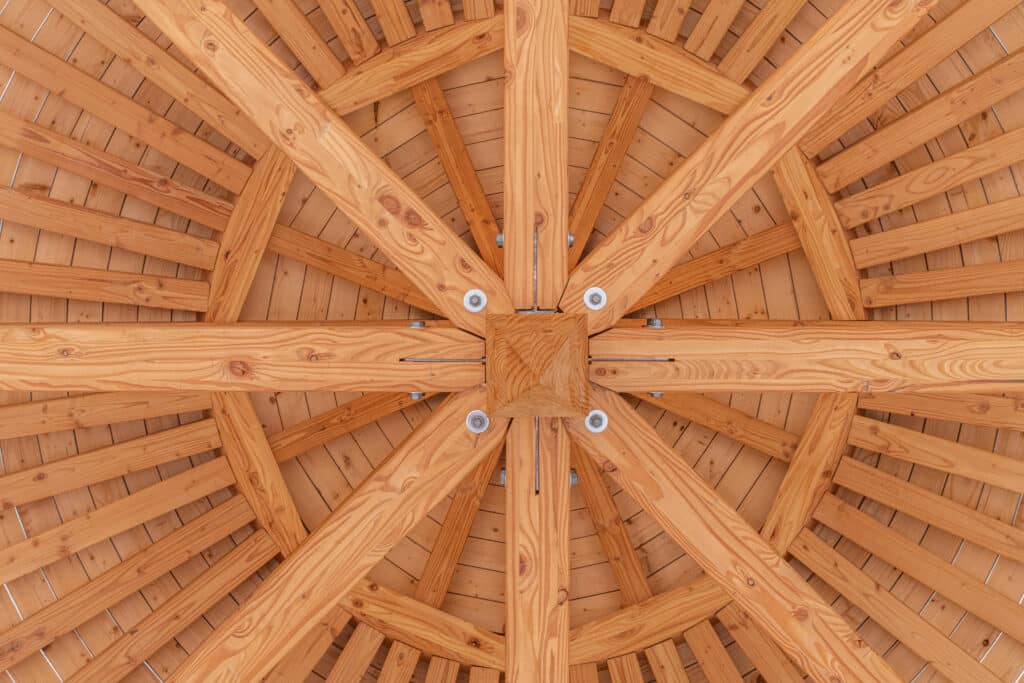 Détail constructif de charpente circulaire en bois lamellé-collé, vue sous toit, structure bois MONOLOG.